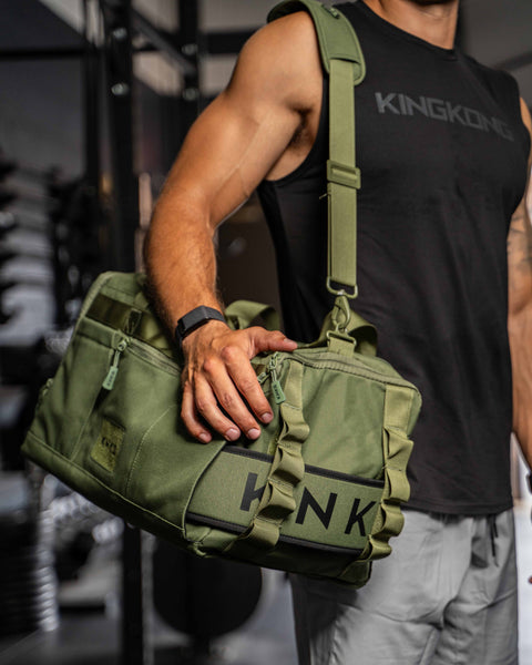 Man wearing green CORE Duffel over shoulder in gym