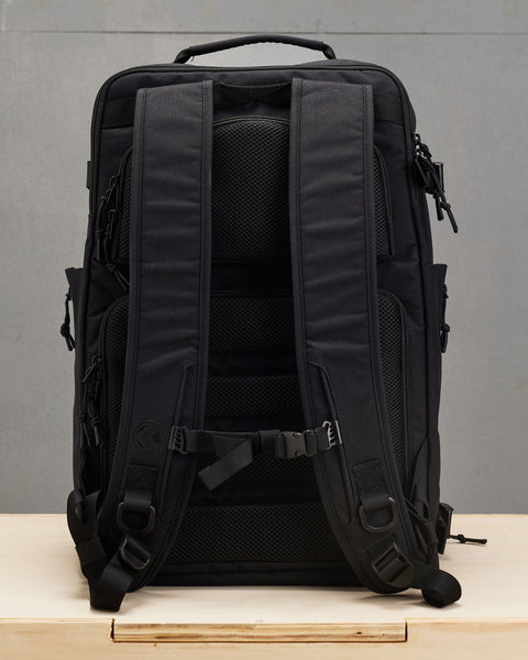 Back view of padded back panels and concealed compartments of large black CONQUER Backpack