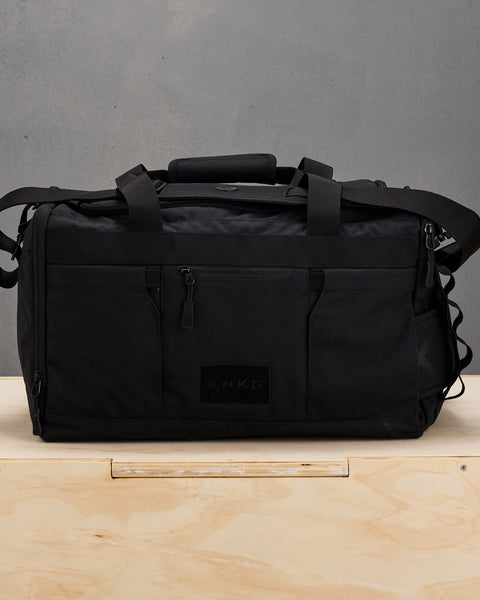 Front view of black CORE Duffel sitting on wooden box