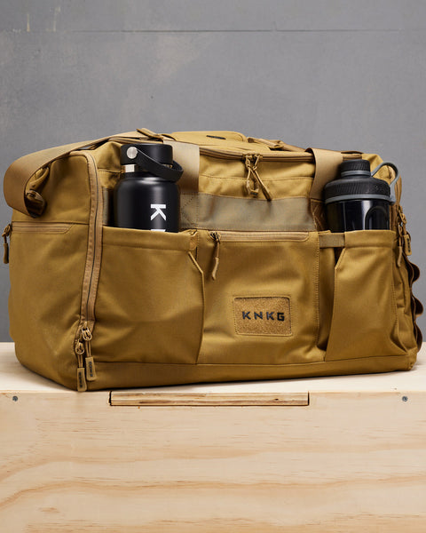 Water bottle and shaker bottle packed inside large desert CORE Duffel bottle pockets