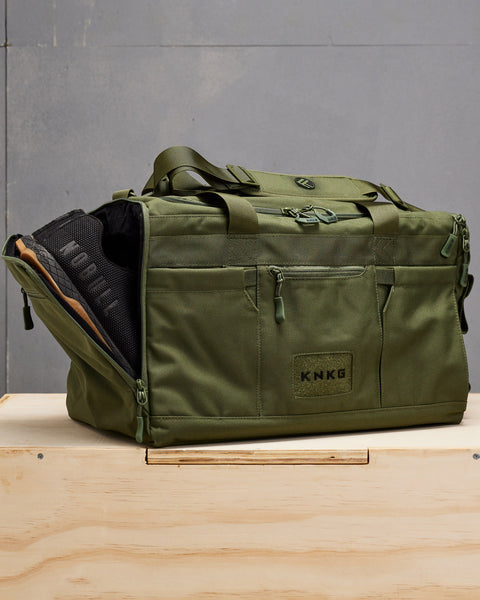 Sneakers packed inside of green CORE Duffel shoe compartment