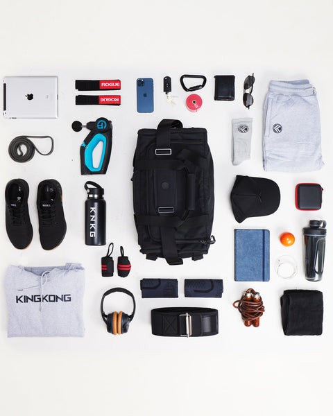 Flat lay of black CORE duffel with gym essentials