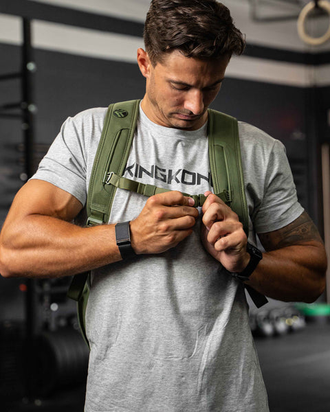 Green CORE Backpack chest strap worn by man in dark gym