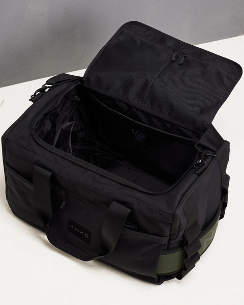 Birds eye view of empty large black KNKG CORE Duffel, showing pockets and compartments