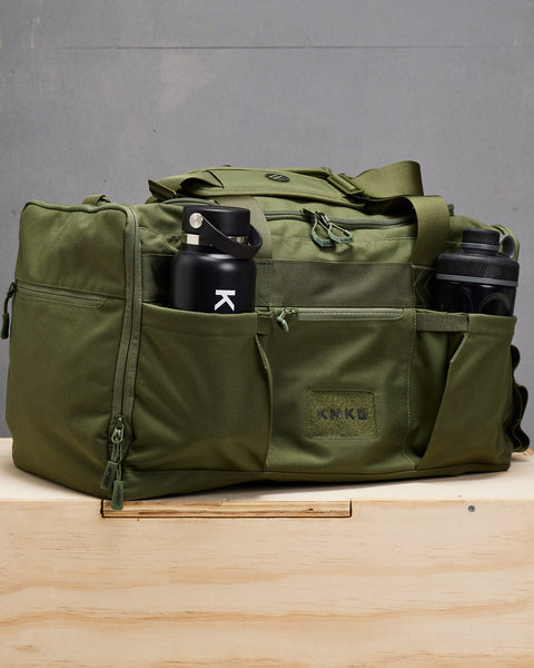 Water bottle and shaker bottle packed inside large green CORE Duffel bottle pockets