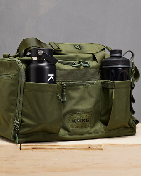 Water bottle and shaker bottle inside green CORE Duffel pockets