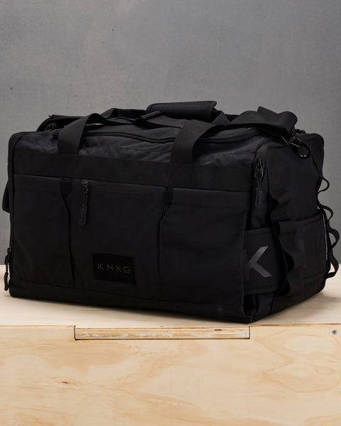 Side profile of Black CORE duffel with matching weight lifting belt attached