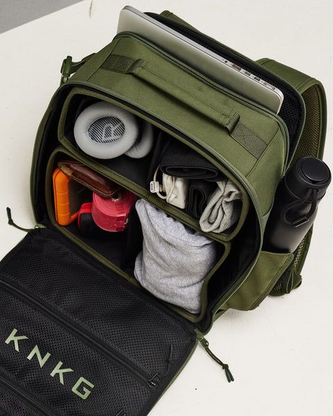 Packed internal dividers, laptop sleeve and bottle pockets of small green KNKG CONQUER Backpack