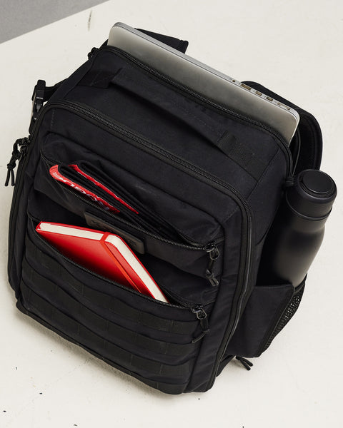 Small black KNKG CONQUER Backpack organized pockets packed with notebook, bottles, wrist wraps and laptop