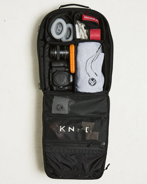 Birds eye view of organized internal dividers of Small black KNKG CONQUER Backpack packed with camera and gym gear
