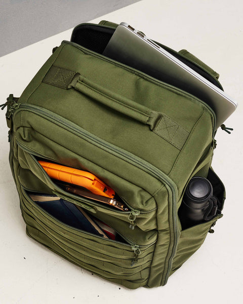 Pockets of large green CONQUER Backpack packed with power bank, phone, notebook, drink bottle and laptop