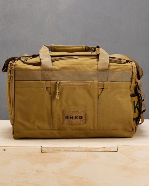 Front view of desert CORE Duffel sitting on wooden box
