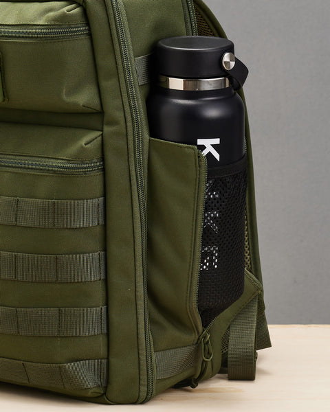 Close up of drink bottle inside mesh side pocket of small green KNKG CONQUER Backpack