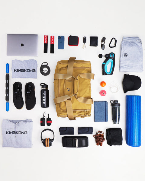 Flat lay of large desert CORE Duffel surrounded by gym gear