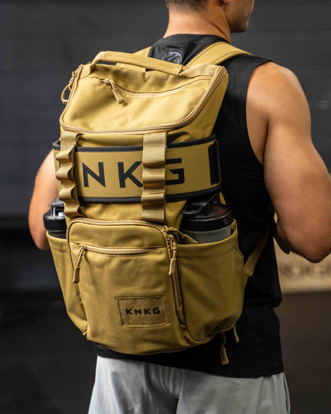 Athlete wearing desert KNKG CORE Backpack in gym