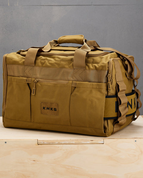 Side view of large desert CORE Duffel with matching lifting belt stowed in belt sleeve