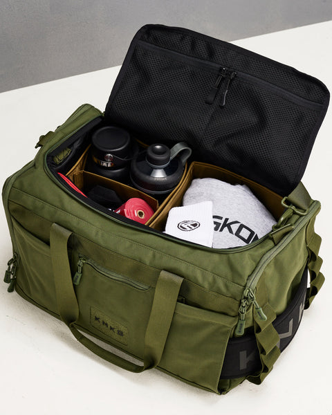 Internal divider organization system inside green CORE Duffel packed with bottles, sweatshirt, socks and mobility accessories