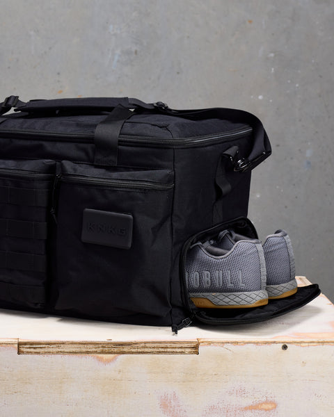 Close up of sneakers inside of black CONQUER Duffel