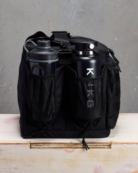 Side view of bottles in mesh pockets of black CONQUER Duffel
