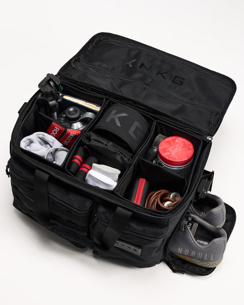 Birds eye view of black CONQUER Duffel with organized dividers packed with gym gear