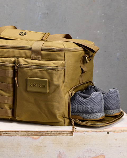 Close up of sneakers inside of desert CONQUER Duffel shoe compartment