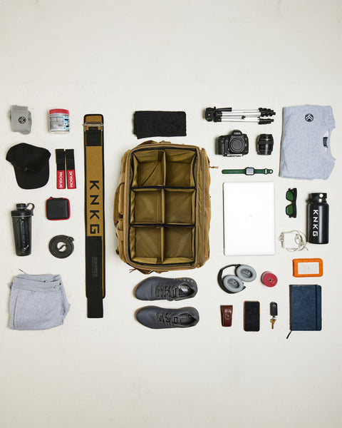 Birds eye view of gym gear being packed inside desert CONQUER Duffel