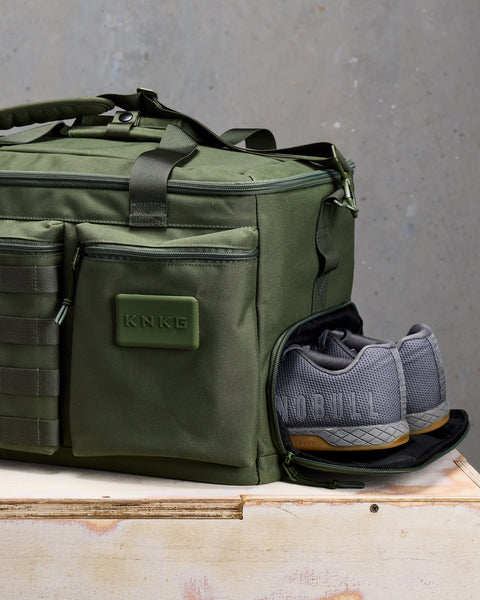 Close up of sneakers inside of Green KNKG CONQUER Duffel shoe compartment