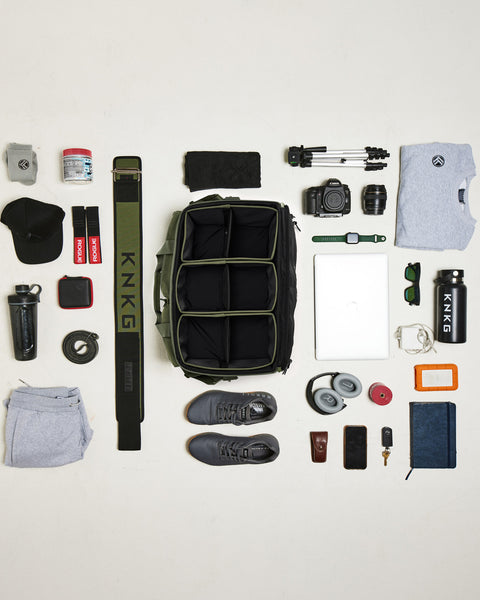 Birds eye view of gym gear that fits inside Green KNKG CONQUER Duffel