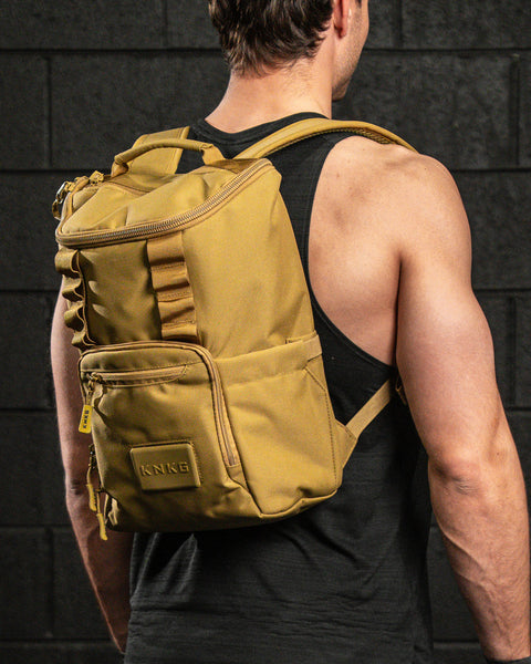 Athlete wearing KNKG CORE Mini Backpack in tactical Desert color