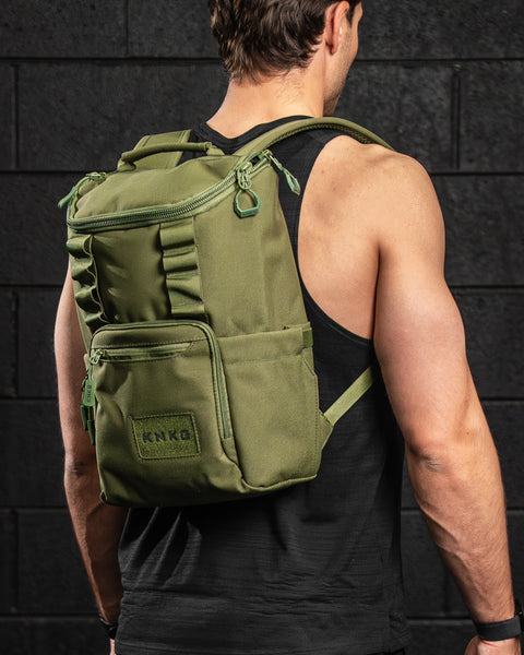 Athlete in gym wearing green mini size KNKG CORE Backpack