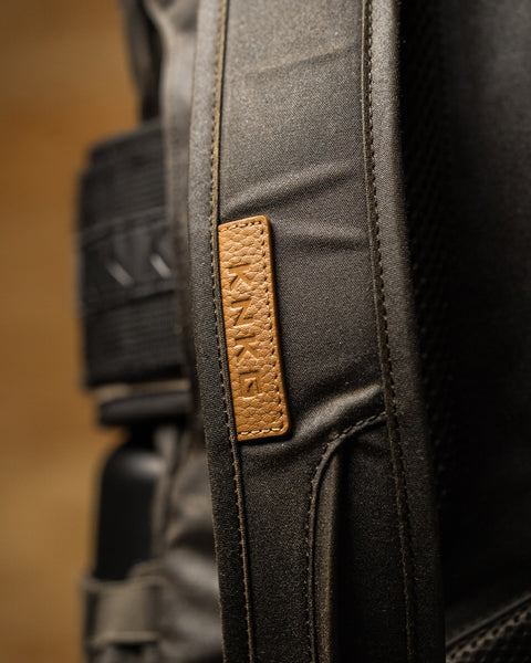 Close up of leather logo patch on KNKG Waxed Canvas Backpack