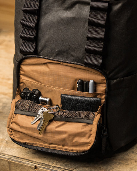 Front pocket of KNKG Waxed Canvas Backpack packed with wallet, keys and EDC essentials
