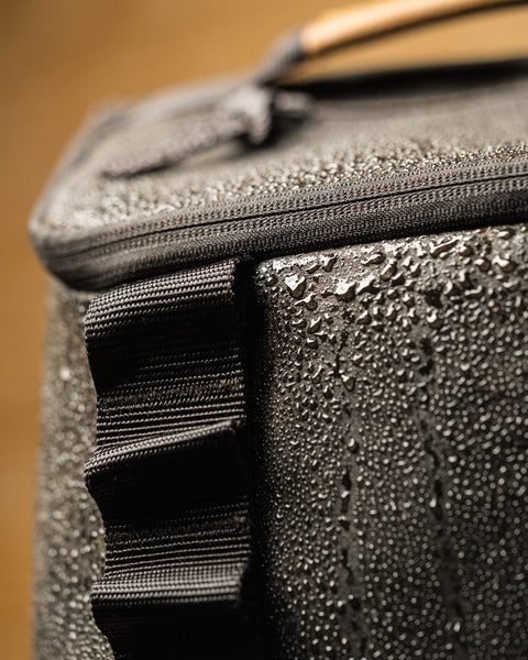 Close up of KNKG Waxed Canvas Backpack with water droplets