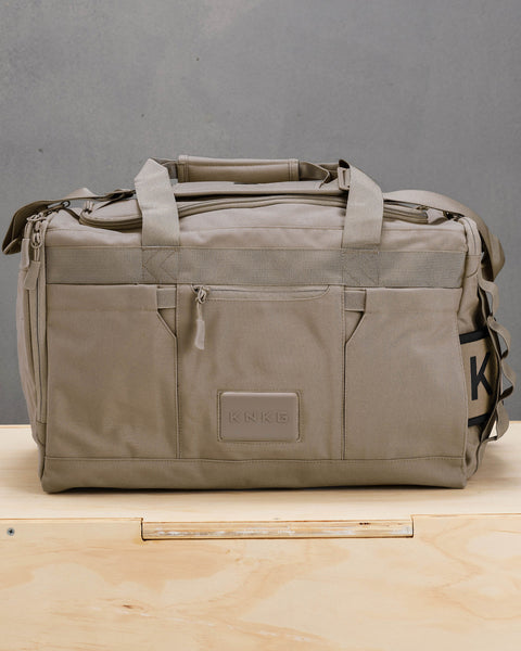 Front view of beige neutral CORE Duffel sitting on wooden box