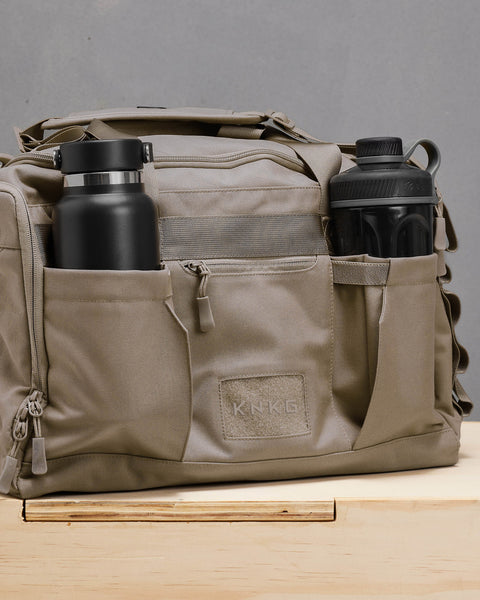 Water and shaker bottles packed inside beige neutral CORE Duffel