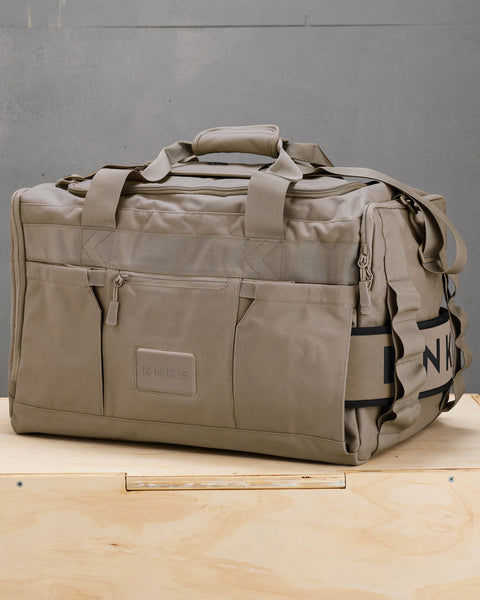 Side view of large neutral beige CORE Duffel showing weight lifting belt stowed in dedicated sleeve
