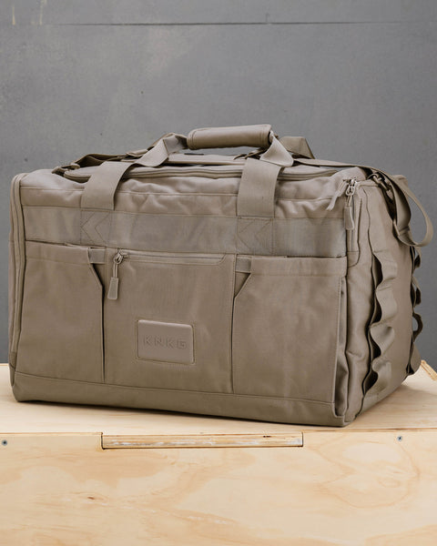 Side view of large neutral beige CORE Duffel sitting on wooden box