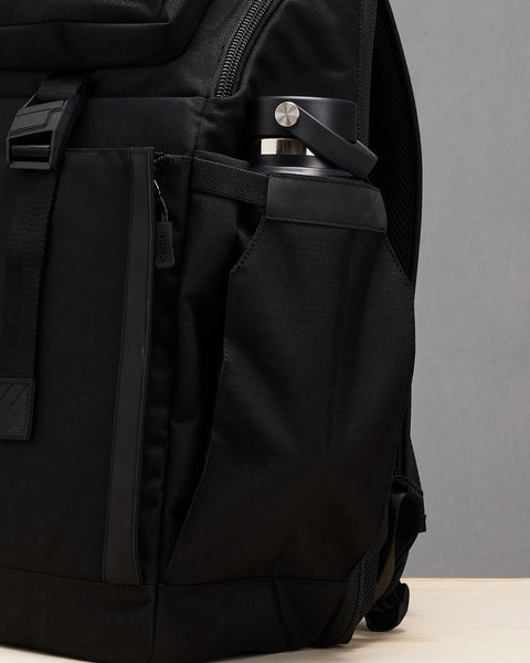 Close up of drink bottle inside of pocket of Black KNKG PLUS Backpack
