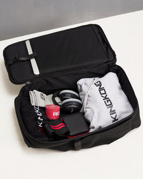Internal of Black KNKG PLUS Backpack flat packed with hoodie, headphones and gym essentials