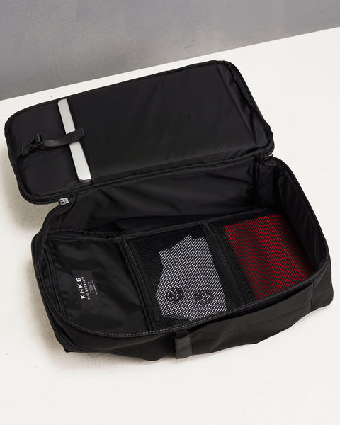 Flat lay of Black KNKG PLUS Backpack open clamshell style