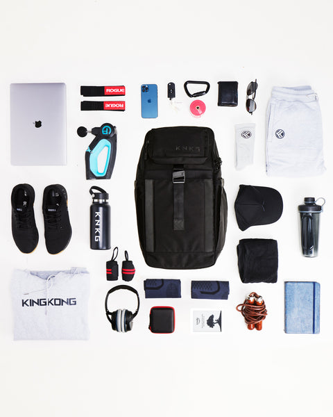 Flay lay of gym gear being packed inside of Black KNKG PLUS Backpack