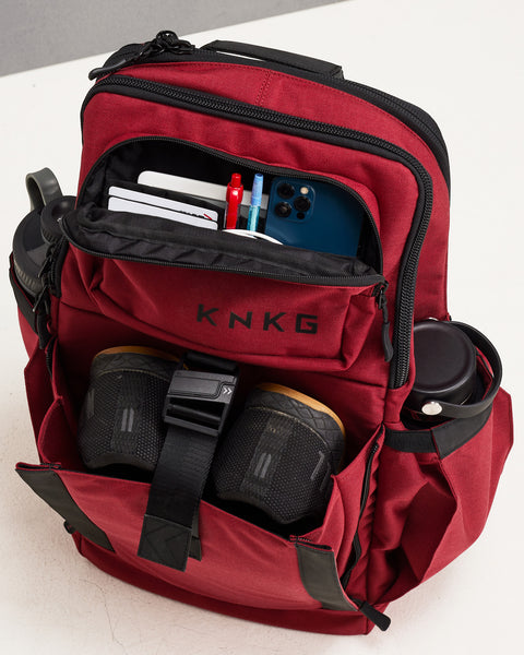 Red KNKG PLUS Backpack fully packed with drink bottles, shoes, phone, keys, bank cards and other essentials