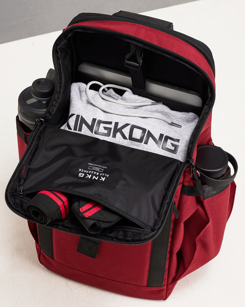 View of internal of Red KNKG PLUS Backpack packed with hoodie, wrist wraps, bottles and laptop