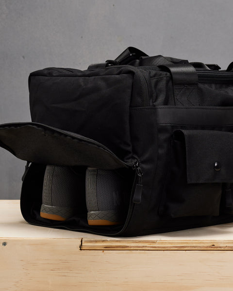 NOBULL sneakers inside small black KNKG PLUS Duffel bag shoe compartment