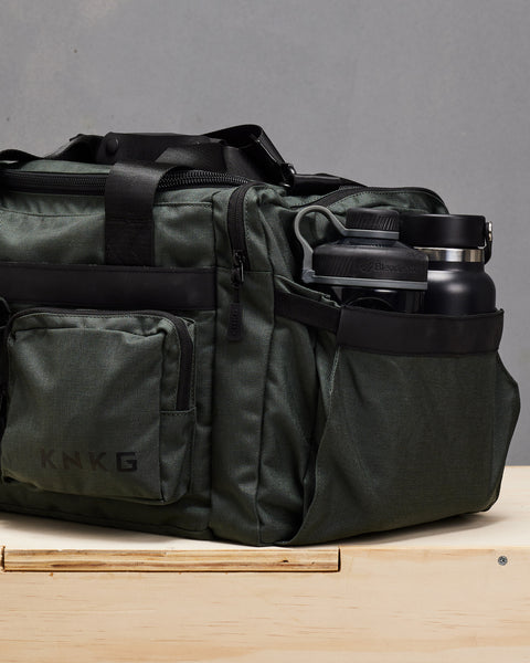 Blender shaker and KNKG drink bottle inside charcoal grey KNKG PLUS duffel bag pocket