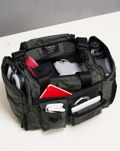 Birds eye view of charcoal grey KNKG PLUS duffel bag pockets and compartments packed with gym gear