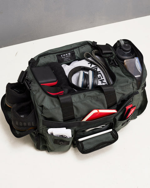 Birds eye view of charcoal grey PLUS Duffel packed with shoes, gym clothes, headphones, bottles and skipping rope