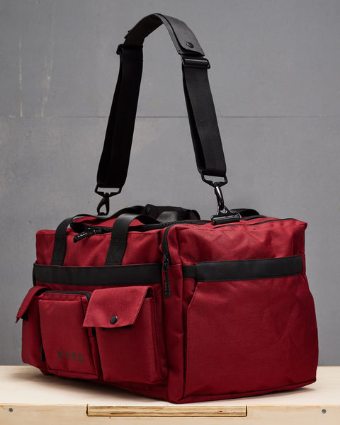 Side pocket view of medium red KNKG PLUS Duffel