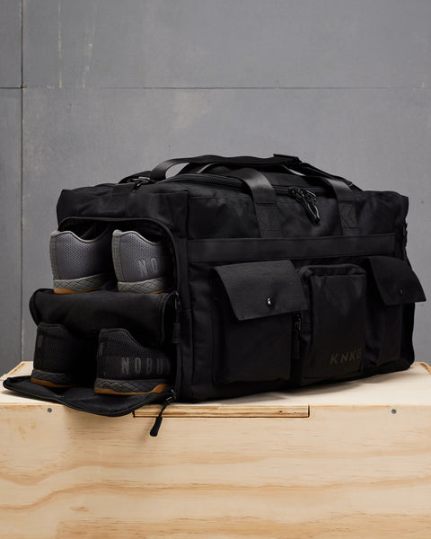 Two shoe compartments packed with sneakers in large black KNKG PLUS duffel