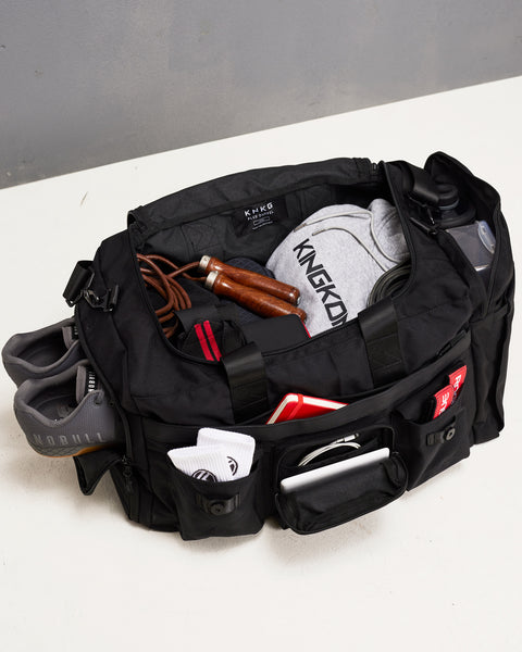Birds eye view of gym essentials packed in large black KNKG PLUS duffel